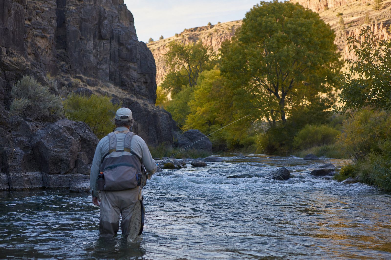 Angler fly fishing a riffle in a basalt canyon